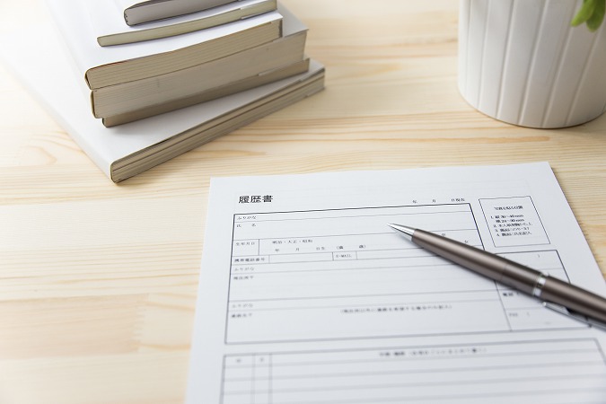 履歴書とペンと積み重なった本